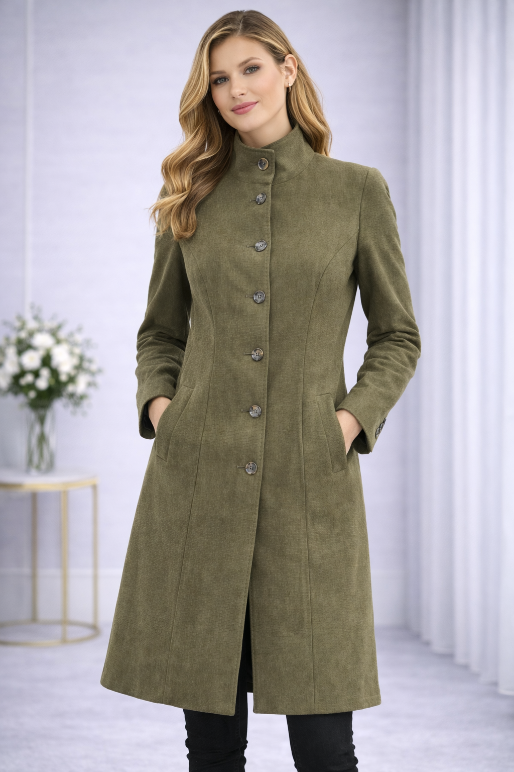 Woman wearing a green coat with buttons in a minimalistic setting