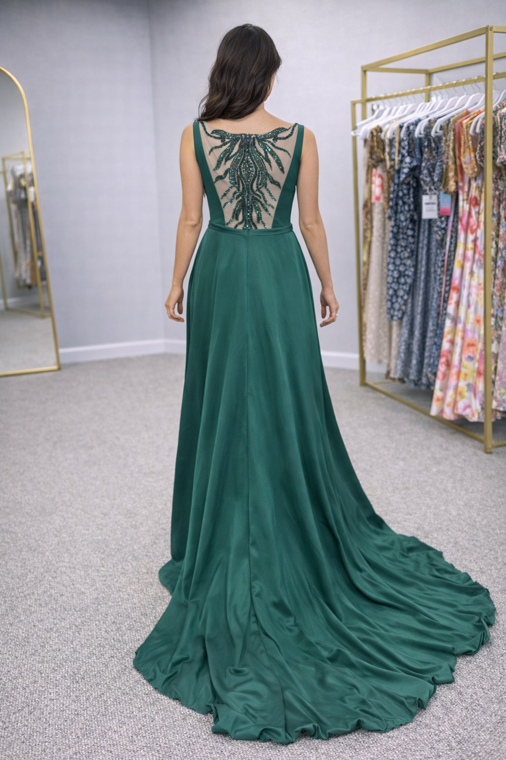 Lalah Woman wearing a green evening gown with intricate back design in a store setting.