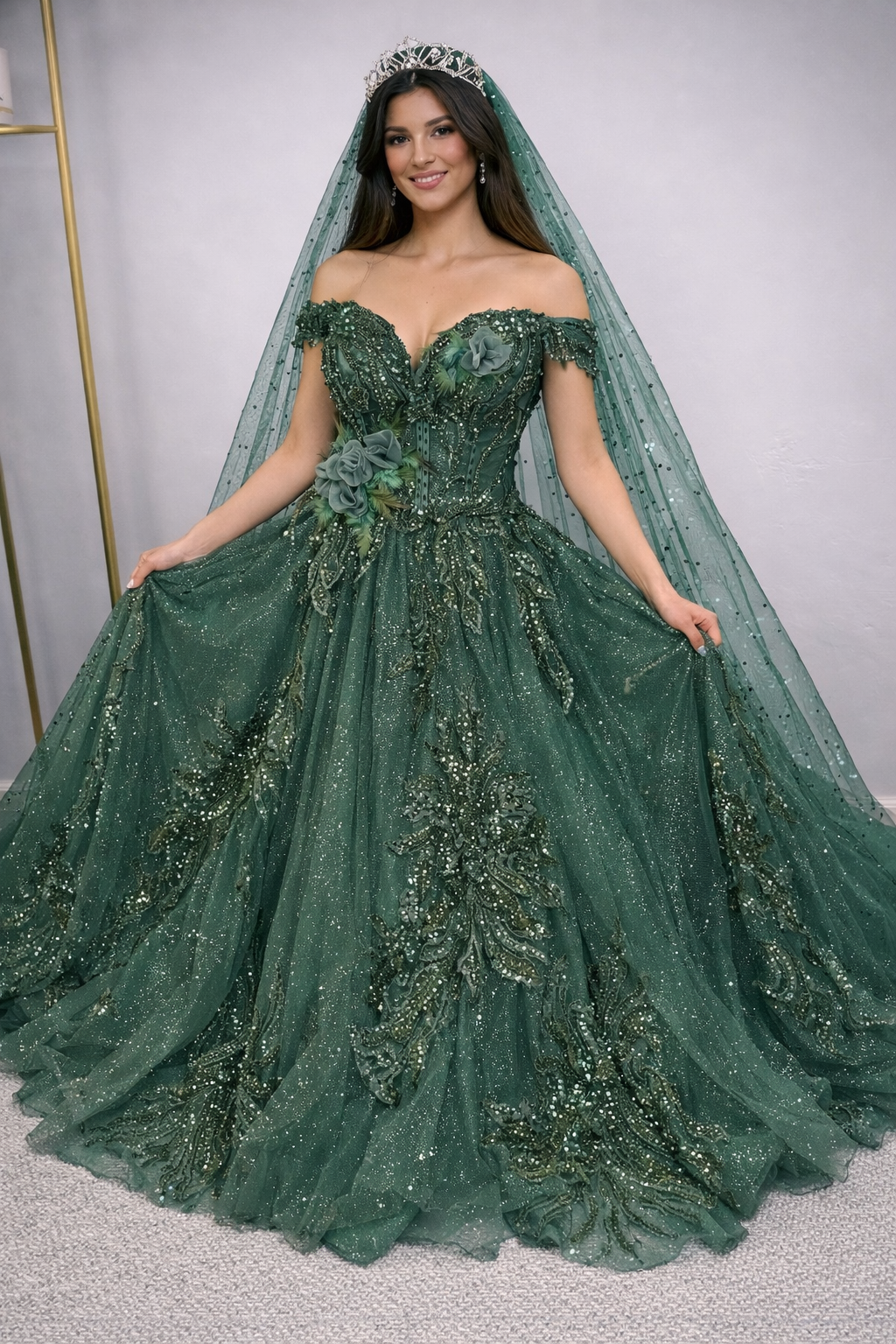 Woman wearing a green evening gown with floral details and a veil.